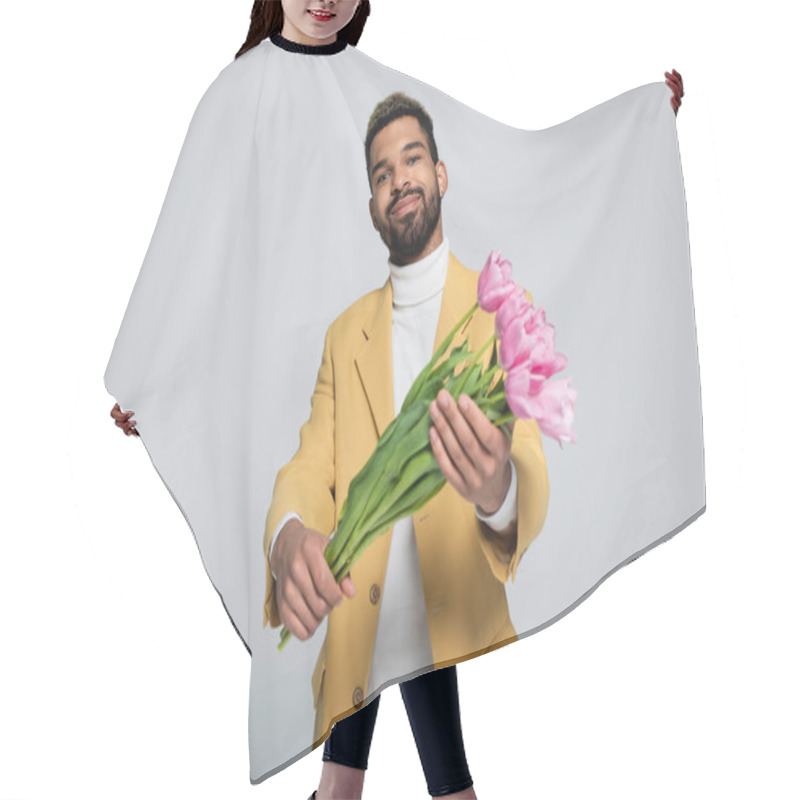 Personality  Pleased African American Man In Stylish Outfit Holding Bouquet Of Pink Tulips Isolated On Grey  Hair Cutting Cape