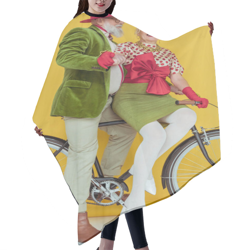 Personality  Senior Woman Smiling At Camera Near Handsome Man On Bicycle On White Surface On Yellow Background Hair Cutting Cape