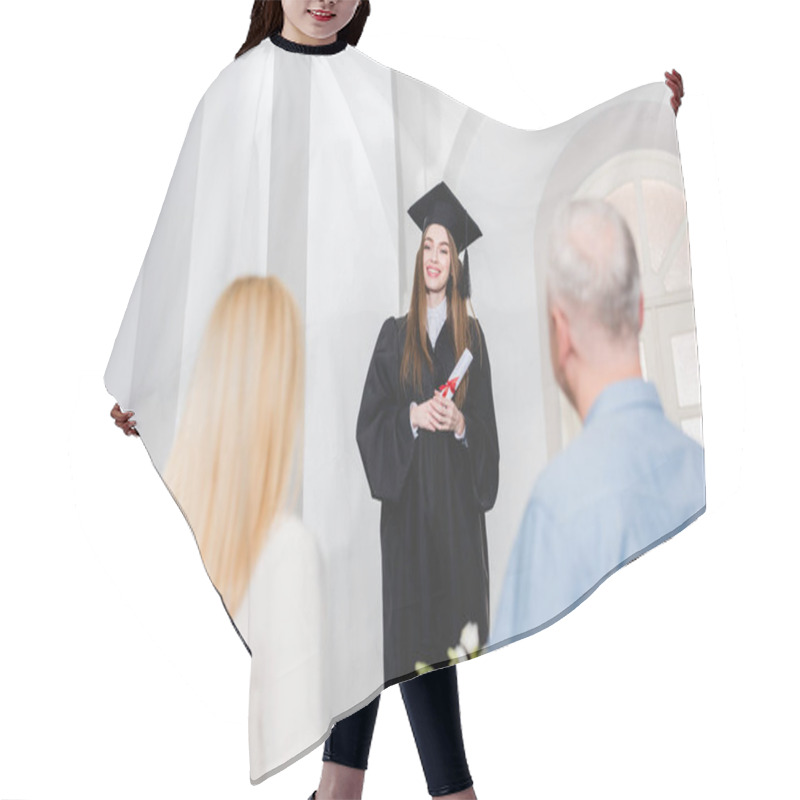 Personality  Selective Focus Of Cheerful Girl In Graduation Cap Looking At Parents And Holding Diploma  Hair Cutting Cape