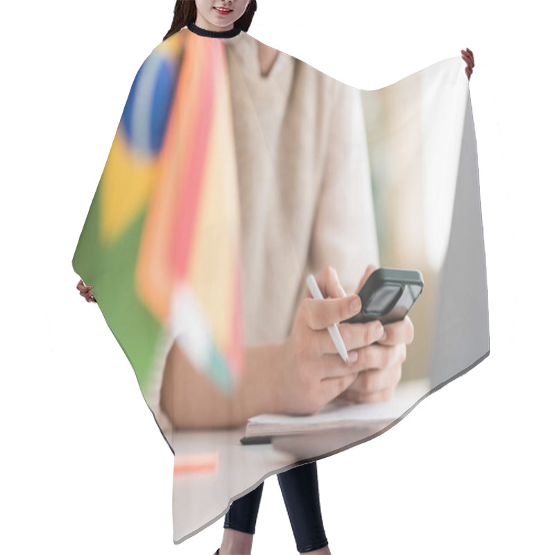 Personality  Cropped View Of Language Teacher Using Mobile Phone Near Laptop And Flags On Blurred Foreground  Hair Cutting Cape