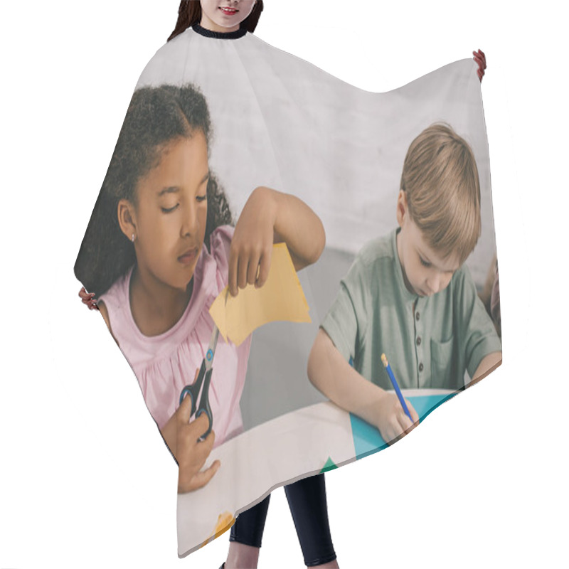 Personality  Portrait Of Multicultural Classmates Sitting At Table With Papers In Classroom Hair Cutting Cape