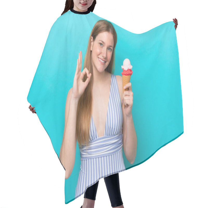 Personality  Young Caucasian Woman In Swimsuit Eating Ice Cream Isolated On Blue Background Showing Ok Sign With Fingers Hair Cutting Cape