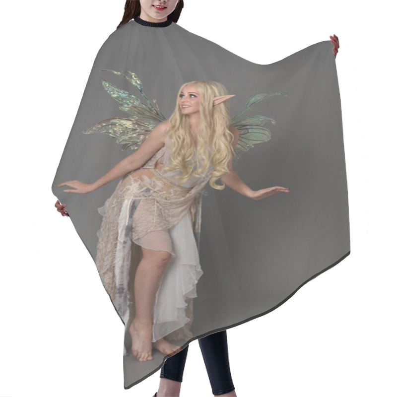 Personality  Full Length Portrait Blonde Girl Wearing Fantasy Fairy Costume, Standing Pose. Grey Studio Background. Hair Cutting Cape