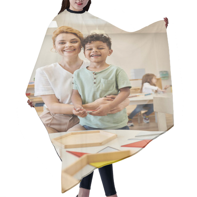 Personality  Smiling Teacher Hugging African American Kid Near Didactic Materials In Montessori School Hair Cutting Cape