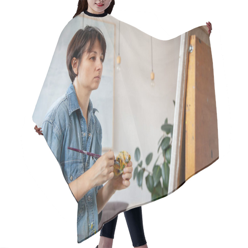 Personality  Concentrated Short-haired Female Artist Painting On Cotton Canvas With Oil Paint At Home. Painter Hair Cutting Cape