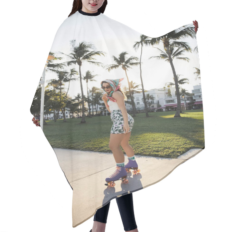 Personality  A Young Woman Wearing Sunglasses And A Stylish Headscarf Rollerblades Down A Miami Sidewalk. Hair Cutting Cape