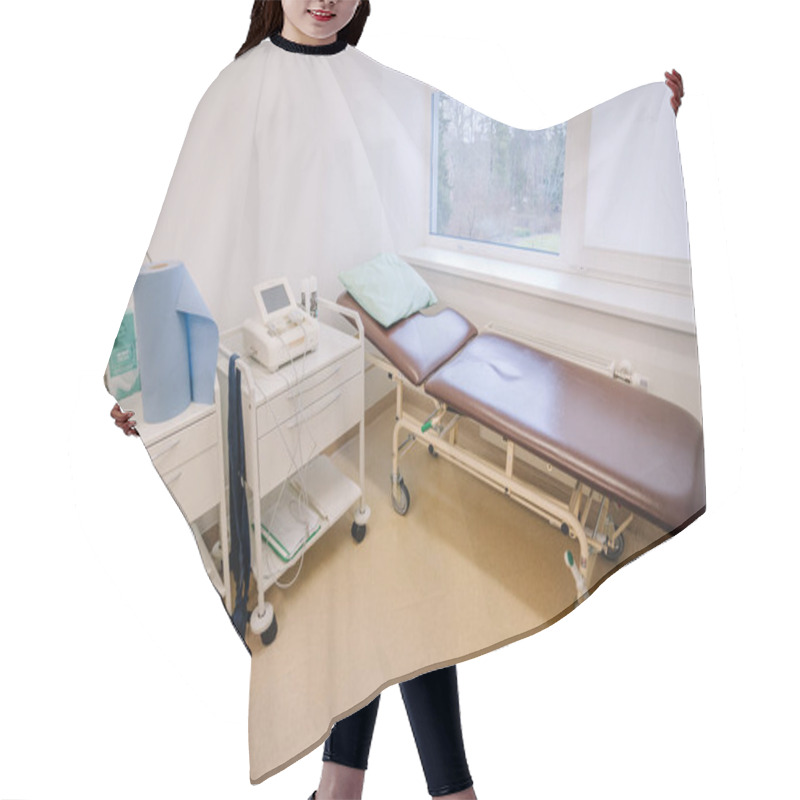 Personality  Valmiera, Latvia - January 17, 2025 -  Examination Room With A Brown Medical Bed, Diagnostic Equipment, And Supplies In A Clean And Well-lit Clinical Setting With A Window View. Hair Cutting Cape