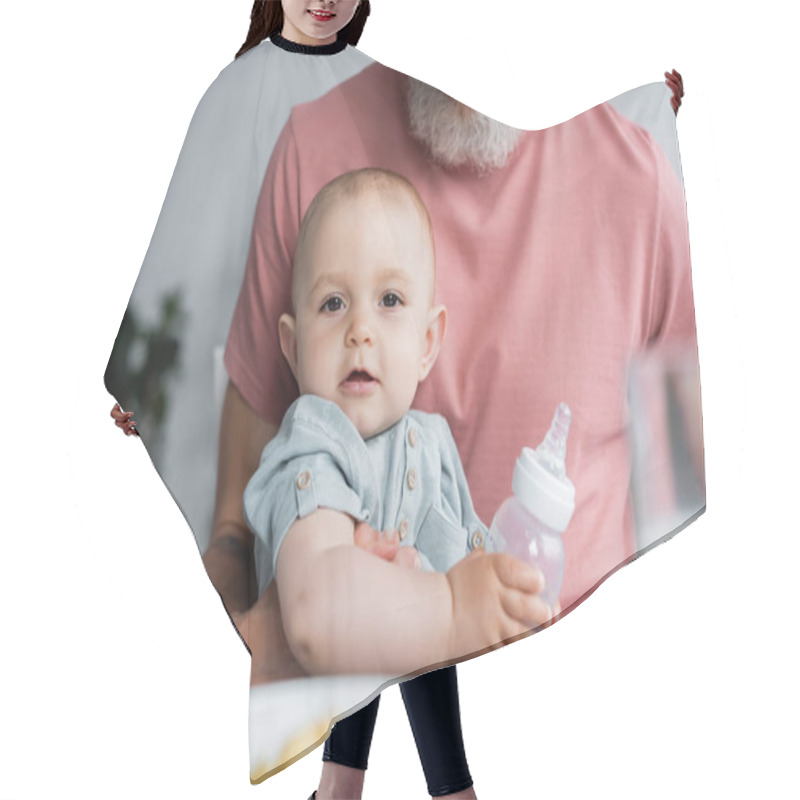 Personality  Baby Girl With Bottle Looking At Camera Near Father  Hair Cutting Cape