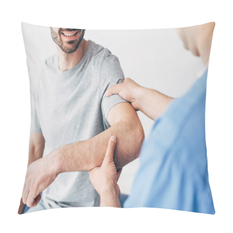 Personality  Selective Focus Of Smiling Patient Sitting On Couch And Chiropractor Examining Patient Shoulder In Massage Cabinet At Clinic  Pillow Covers