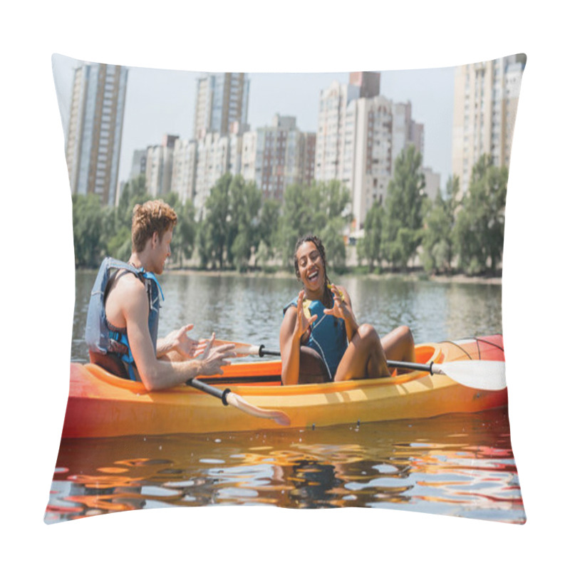 Personality  Cheerful African American Woman In Life Vest Gesturing Near Young Redhead Man And Having Fun In Sportive Kayak On Lake With Modern Buildings On Background Pillow Covers