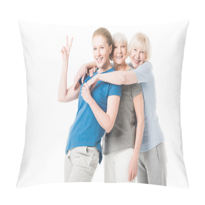 Personality  Mature Sportswoman Showing Peace Gesture While Two Senior Sportswomen Embracing Her Isolated On White Pillow Covers