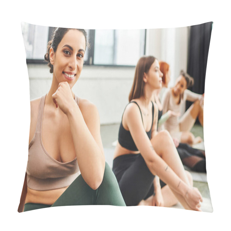 Personality  Cheerful Multiracial Woman In Sportswear Looking At Camera Near Multiethnic Female Friends Sitting On Blurred Background During Yoga Class, Wellness And Mental Health Concept Pillow Covers