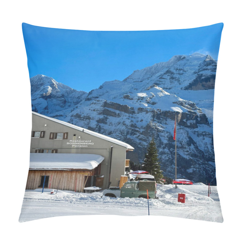 Personality  The Restaurant Is Nestled In A Snow-covered Area In Murren, Switzerland, With Breathtaking Views Of Towering Alpine Peaks. A Swiss Flag Waves Near An Evergreen Tree. The Bright Blue Sky Enhances The Atmosphere Of The Ski Village. Pillow Covers