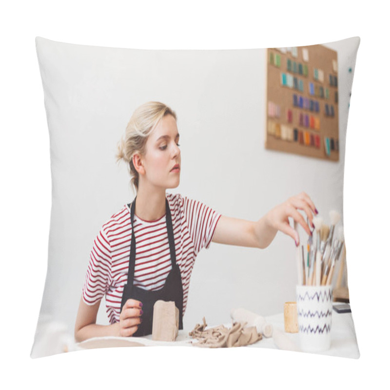 Personality  Beautiful Girl In Black Apron And Striped T-shirt Sitting At The Table With Clay Thoughtfully Selecting Tools At Pottery Studio Pillow Covers