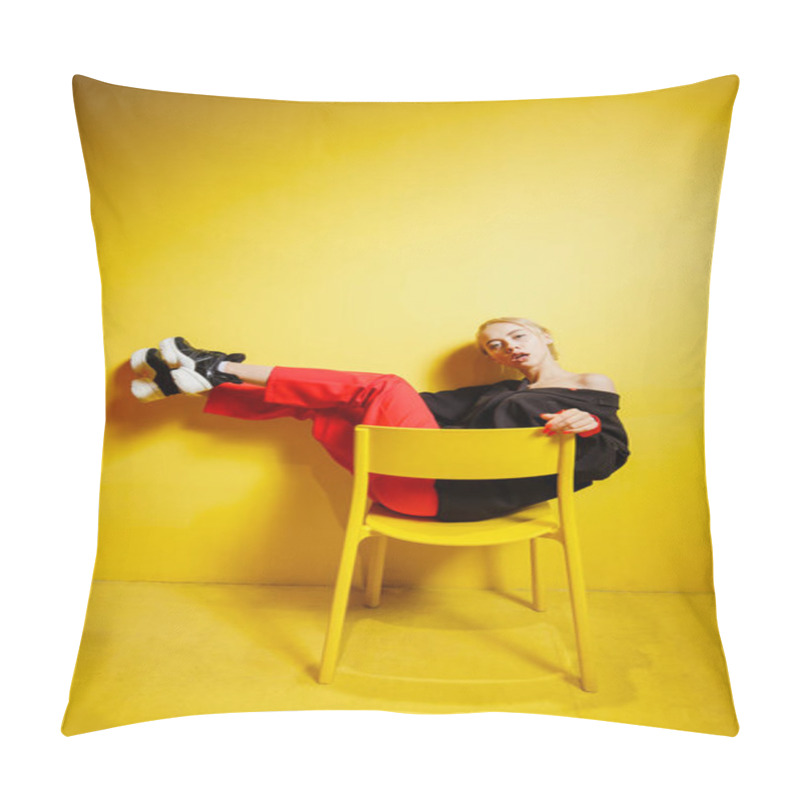 Personality  Young Fashion Girl Blogger Dressed In Red Trousers And Black Jacke Possing Sitting On The Stool In The Room With Yellow Walls And Furniture Pillow Covers