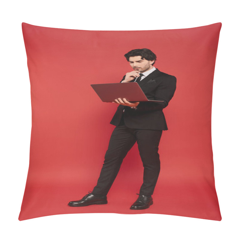 Personality  Stylish Young Man In Formal Attire Thinks Deeply While Standing With A Laptop On Red Background. Pillow Covers