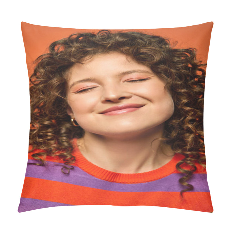 Personality  A Young Woman With Curly Brown Hair Smiles Brightly While Wearing A Striped Sweater Against A Vibrant Orange Background. Pillow Covers