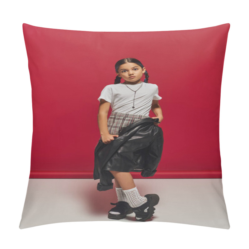 Personality  Preadolescent And Fashionable Girl With Hairstyle Wearing Plaid Skirt And Holding Leather Jacket While Looking At Camera And Posing On Red Background, Hairstyle And Trendy Accessories Concept Pillow Covers