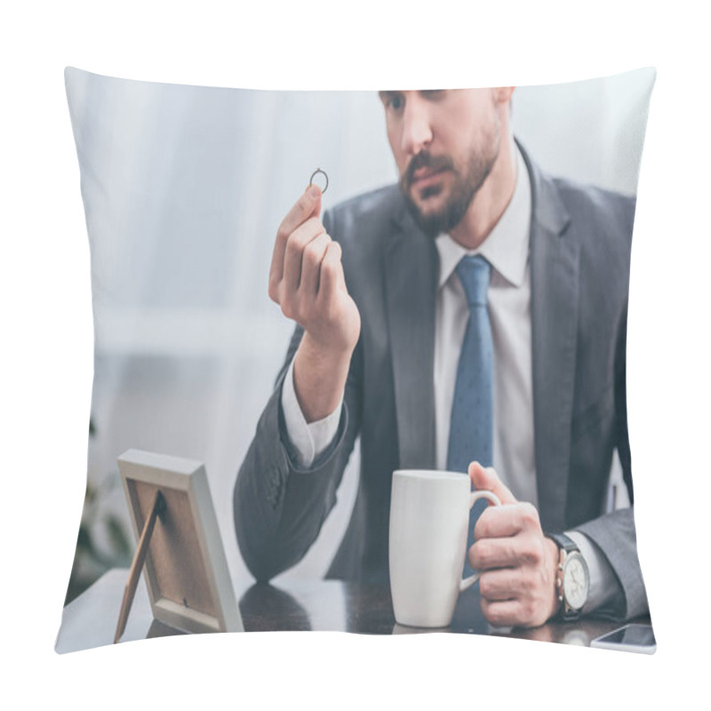 Personality  Selective Focus Of Sad Man In Gray Suit Sitting At Wooden Table And Looking At Ring In Room, Grieving Disorder Concept Pillow Covers