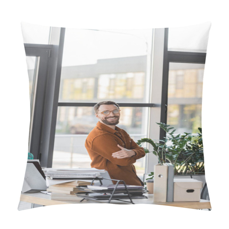 Personality  Happy Bearded Businessman In Eyeglasses And Shirt Smiling At Camera While Standing With Crossed Arms Next To Windows And Workplace With Pile Of Books, Notebooks, Folders, Carton Box And Paper Cup  Pillow Covers