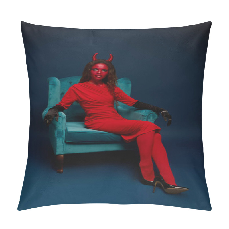 Personality  A Striking Woman Dressed As A Devil Lounges In A Teal Chair, Exuding Halloween Spirit. Pillow Covers