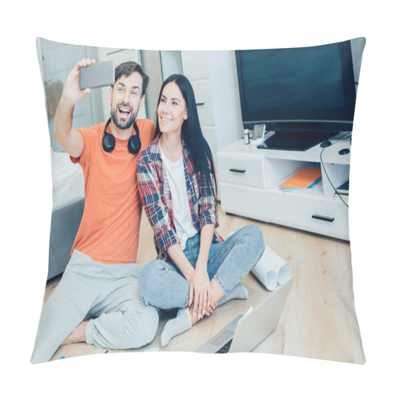 Personality  Cheerful Young Man Sitting With A Beautiful Lady And Holding A Smartphone While Taking Photos With Her. Laptop And Charts On The Floor Pillow Covers