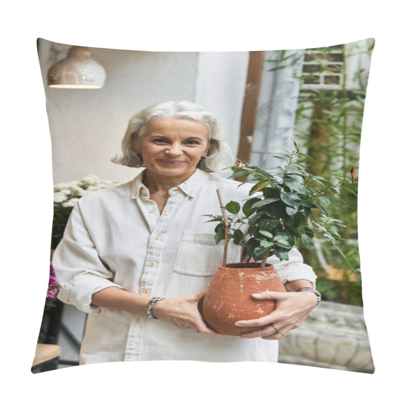 Personality  A Mature Woman Smiles Warmly While Holding A Lovely Potted Plant In A Vibrant Shop. Pillow Covers