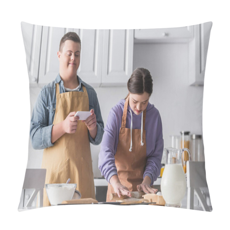 Personality  Teenager With Down Syndrome Making Dough Near Ingredients And Friend Holding Smartphone In Kitchen  Pillow Covers