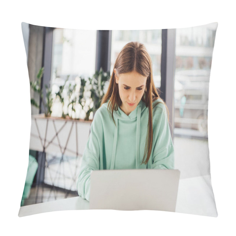 Personality  Focused Girl In Casual Hoodie Sitting At Table And Using Laptop Pillow Covers