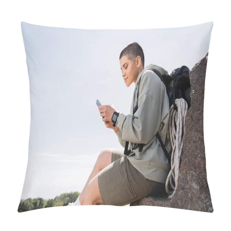 Personality  Young Short Haired Female Traveler With Backpack And Travel Equipment Using Smartphone While Sitting On Stone With Nature And Blue Sky At Background, Vibrant Travel Experiences, Summer Pillow Covers