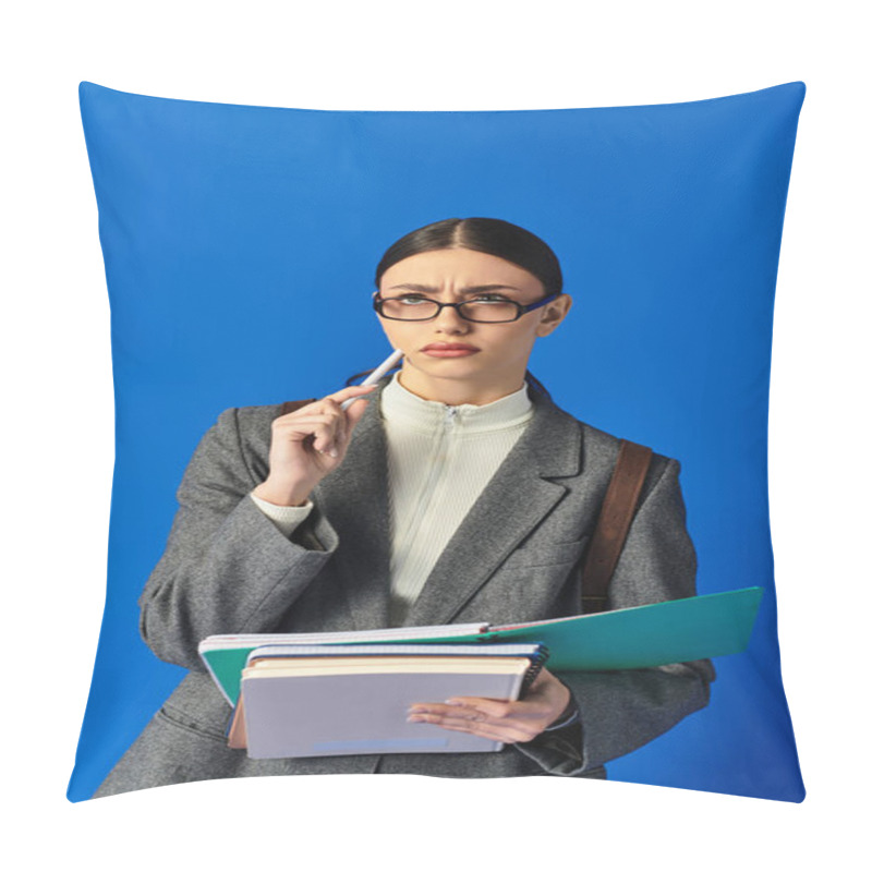 Personality  A Young Woman In Glasses Looks Thoughtful, Holding Notebooks And A Pen Against A Blue Background. Pillow Covers