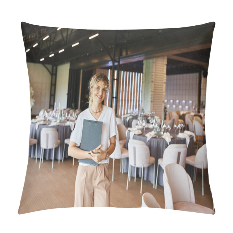 Personality  Smiling Blonde Event Manager With Clipboard Looking At Camera In Banquet Hall With Decorated Tables Pillow Covers