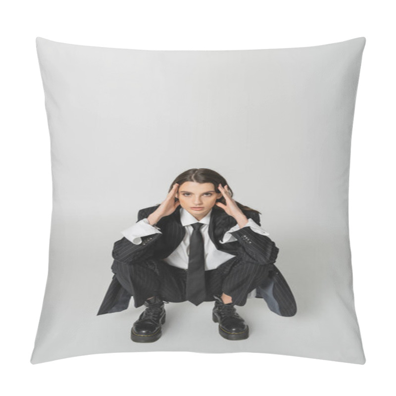 Personality  Brunette Woman In Black Striped Suit And Rough Boots Holding Hands Near Face And Looking At Camera While Sitting On Grey  Pillow Covers