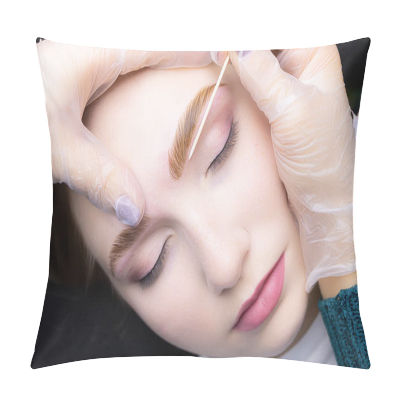 Personality  close-up alignment of the contour of the eyebrows with a cotton swab after the procedure lamination and coloring of the eyebrows pillow covers