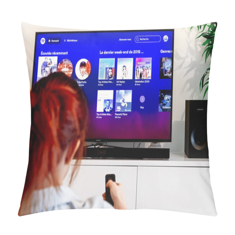 Personality  Benon, France - December 30, 2018: Woman Holding A TV Remote Control Facing A Screen Displaying In French Language Spotify Menu. Spotify Is A Swedish Music Streaming Service. Pillow Covers