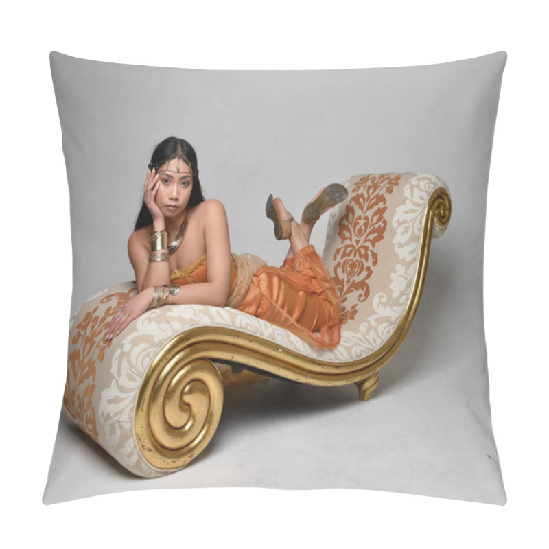 Personality  Full Length Portrait Of Pretty Young Asian Woman Wearing Golden Arabian Robes Like A Genie, Seated Pose On Lounge, Isolated On Studio Background. Pillow Covers