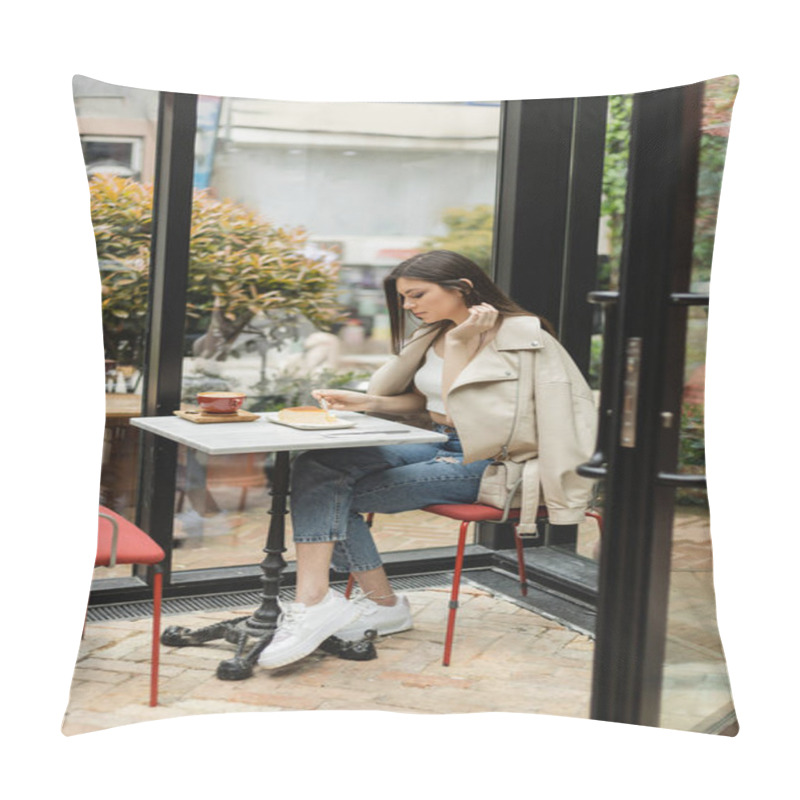 Personality  Full Length Of Young Woman With Long Hair Holding Fork Near Cheesecake And Cup Of Cappuccino On Bistro Table While Sitting In Leather Jacket Next Window Inside Of Modern Cafe In Istanbul  Pillow Covers