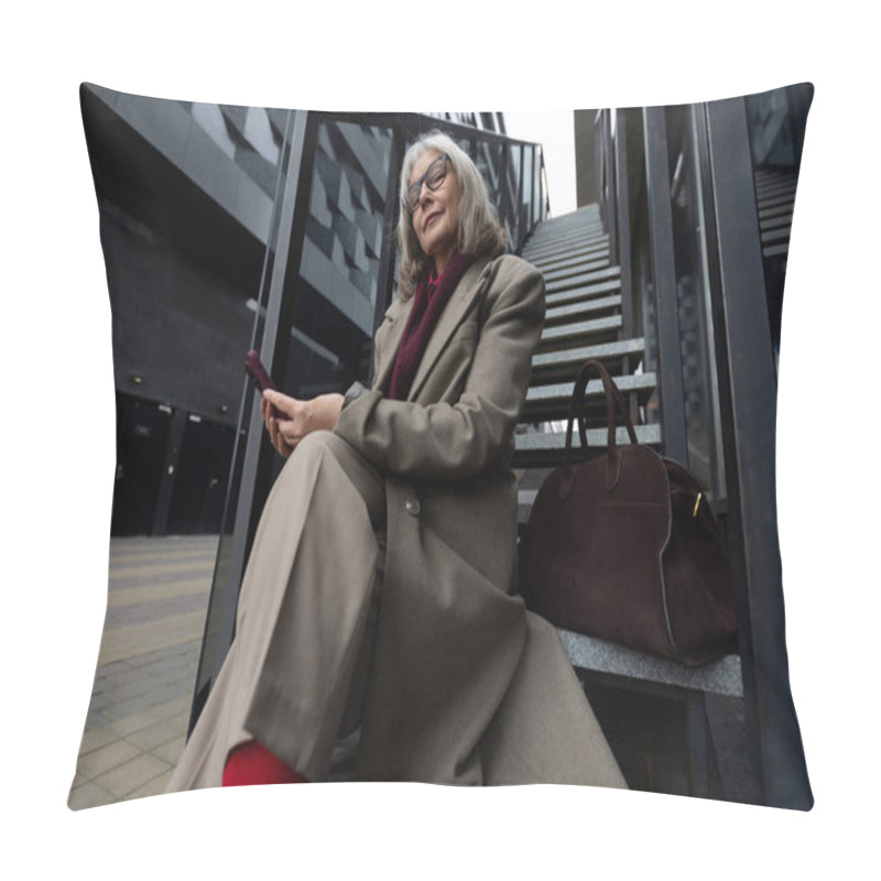 Personality  A Mature Businesswoman Dressed In A Stylish Coat And Vibrant Red Stockings Sits On The Stairs Of A Contemporary Building, Focused On Her Smartphone While Enjoying The Urban Atmosphere. Pillow Covers