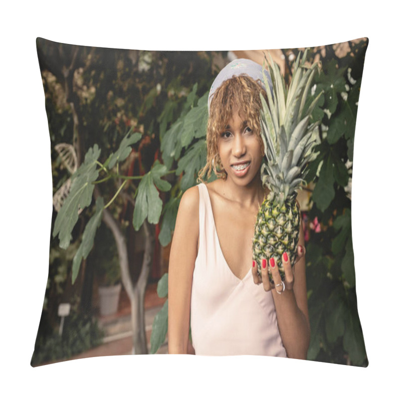 Personality  Cheerful Young African American Woman With Braces In Summer Outfit Holding Juicy Pineapple And Looking At Camera In Blurred Orangery, Woman In Summer Outfit Posing Near Lush Tropical Plants Pillow Covers