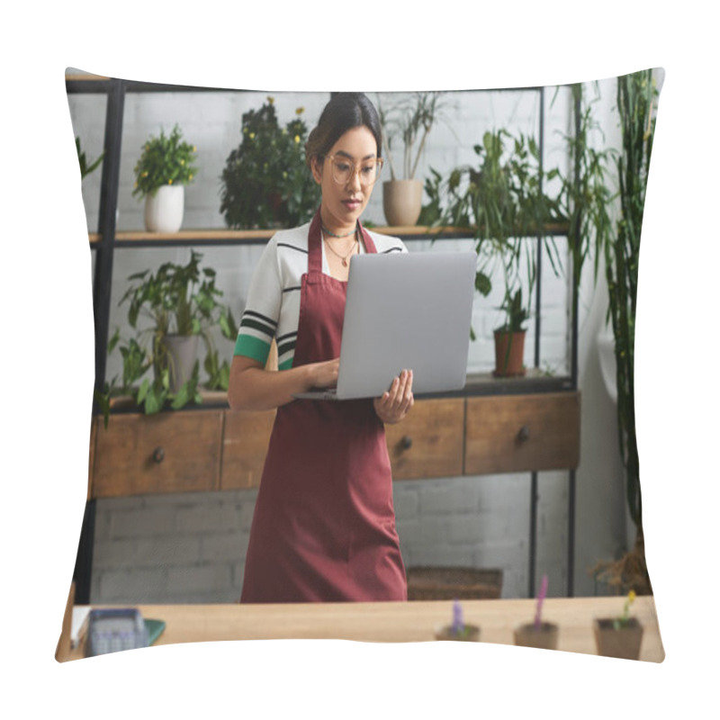 Personality  A Young Asian Woman, Wearing An Apron, Stands In Her Plant Store And Uses Her Laptop To Manage Her Business Online. Pillow Covers