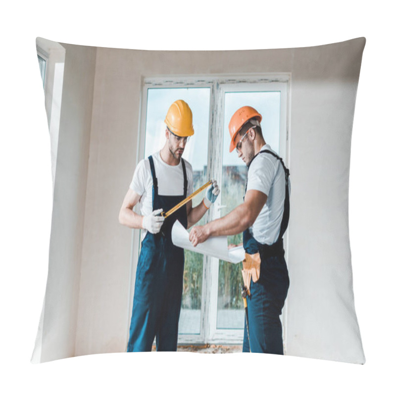 Personality  Handsome Builder Looking At Blueprint Near Coworker Holding Measuring Tape  Pillow Covers