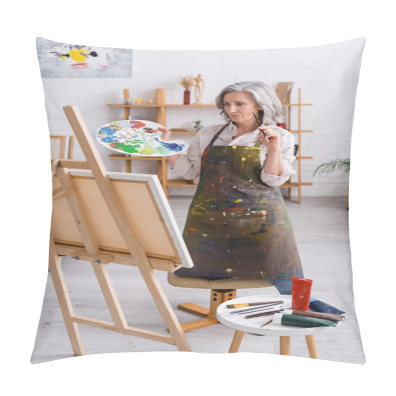 Personality  Mature Artist Holding Paintbrush And Palette While Standing Near Canvas  Pillow Covers