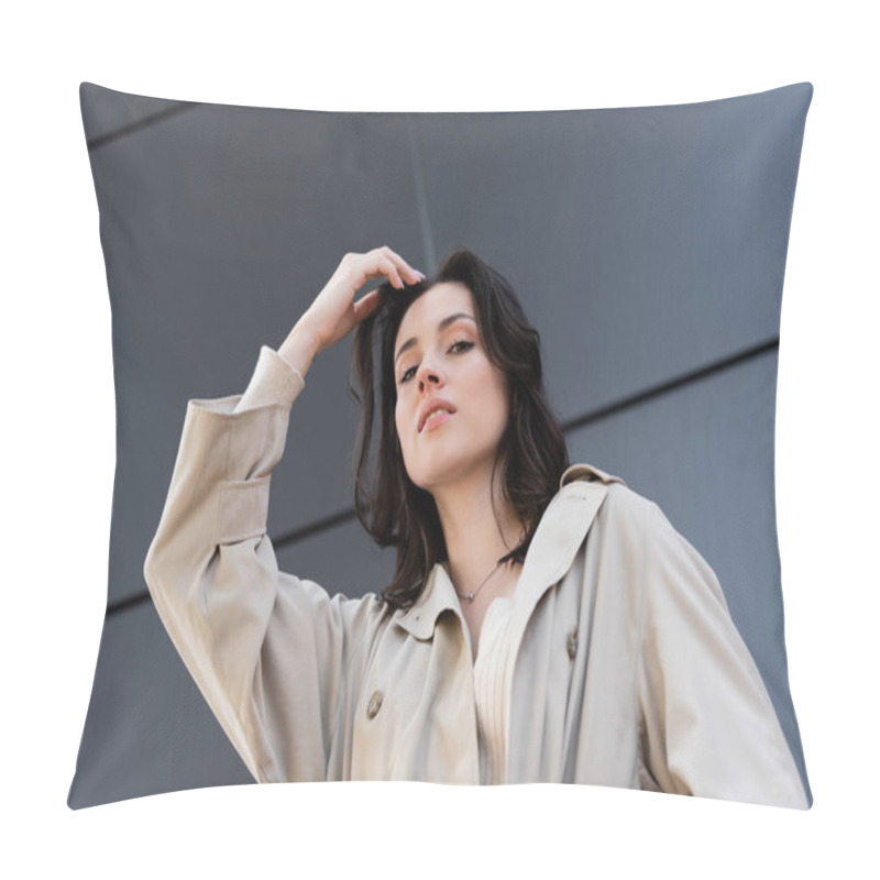 Personality  Low Angle View Of Brunette Woman In Beige Coat Posing With Hand Near Head Outdoors Pillow Covers