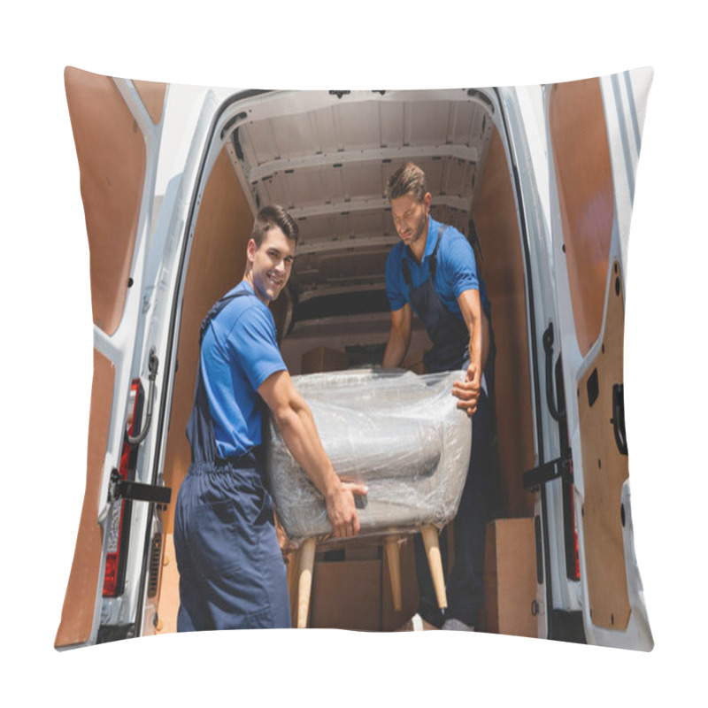 Personality  Loader Looking At Camera While Holding Armchair With Colleague In Truck Outdoors  Pillow Covers