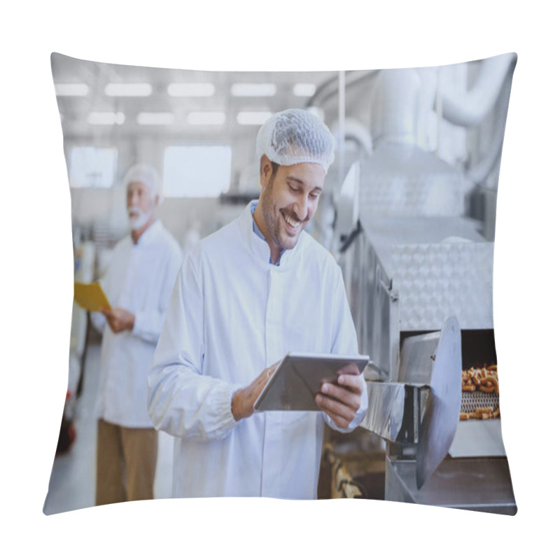 Personality  Young Smiling Supervisor In Sterile White Uniform Using Tablet And Checking Quality Of Salty Sticks. In Background Older Supervisor Holding Folder With Documents. Food Plant Interior. Pillow Covers