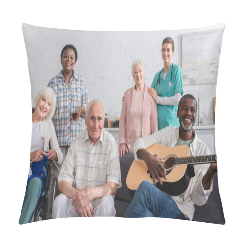 Personality  Positive Interracial Pensioners With Yarn And Acoustic Guitar Looking At Camera Near Nurse In Nursing Home  Pillow Covers