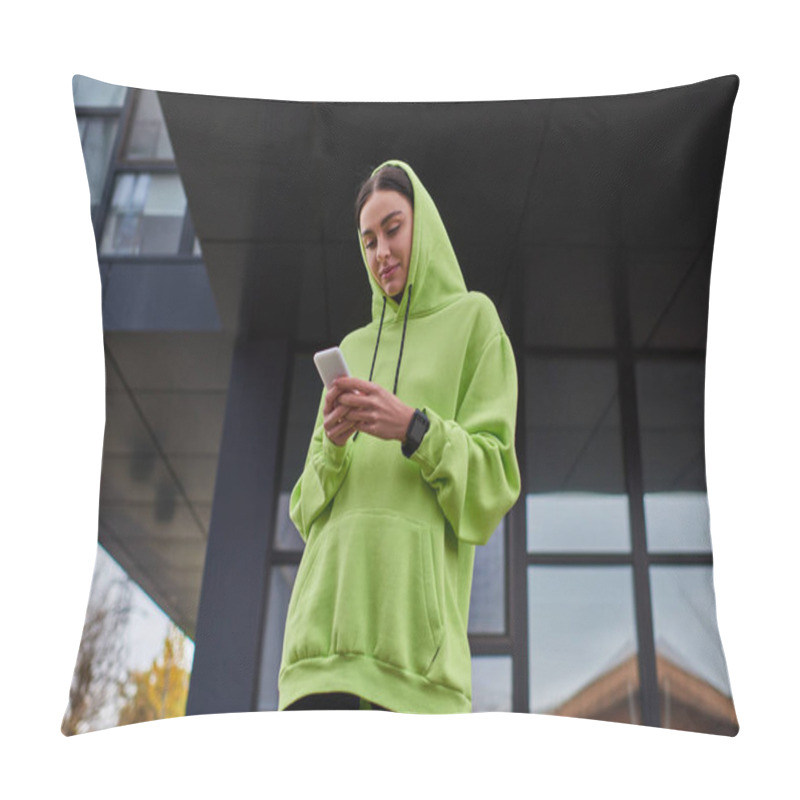 Personality  Young Brunette Sportswoman With Hood On Head Using Smartphone Near Modern Building, Street Style Pillow Covers