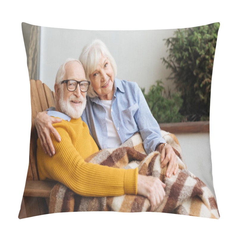 Personality  Happy Senior Couple With Plaid Blanket Looking At Camera While Hugging In Armchair On Blurred Background On Terrace Pillow Covers