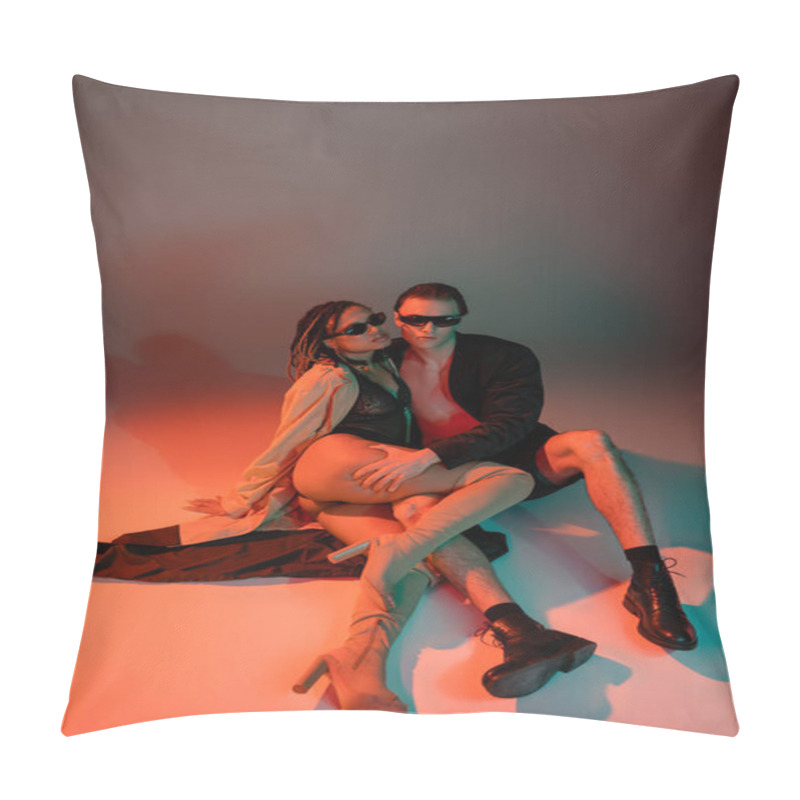 Personality  High Angle View Of Trendy Man In Black Blazer And Shorts Near African American Woman In Dark Sunglasses, Lace Bodysuit, Beige Trench Coat And Over Knee Boots On Grey Background With Red Lighting Pillow Covers