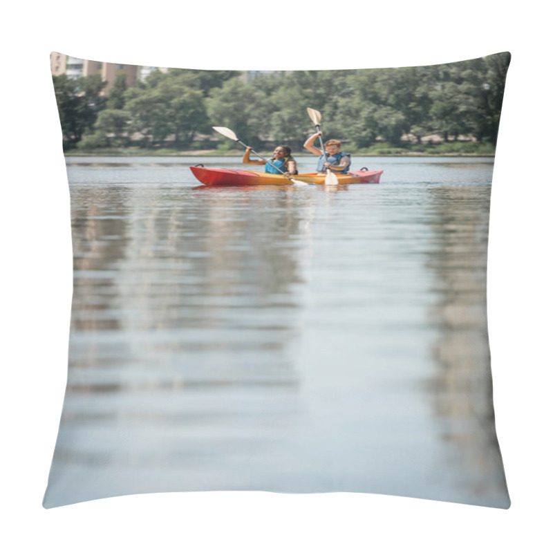 Personality  Young Active Man And African American Woman In Life Vests Sailing In Sportive Kayak With Paddles On Blurred Water Surface With Green Riverside On Background Pillow Covers